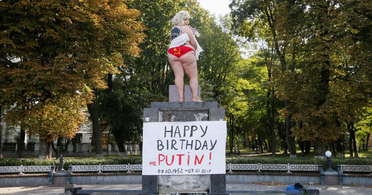У центрі Києва оголена активістка Femen з надгробком Путіна на спині, "привітала" його з 65-річчям 