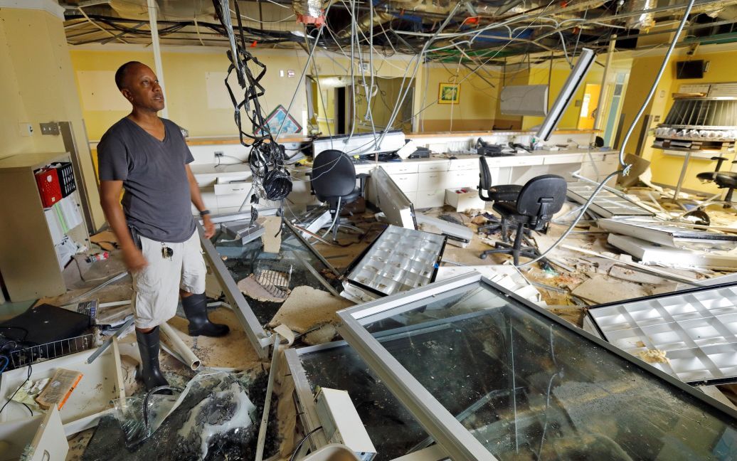 Даррил Рис, старший директор регионального медицинского центра Шнайдер, осматривает мусора во время медиа-турне о повреждении главного больничного комплекса острова, Сент-Томас. / © Reuters