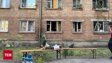 У Києві дитина спостерігає за тим, як батьки розбирають завали їхнього будинку