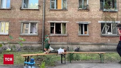В Киеве ребенок наблюдает за тем, как родители разбирают завалы их дома