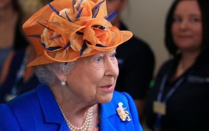 В синем пальто и оранжевой шляпе: королева Елизавета проведала пострадавших в теракте