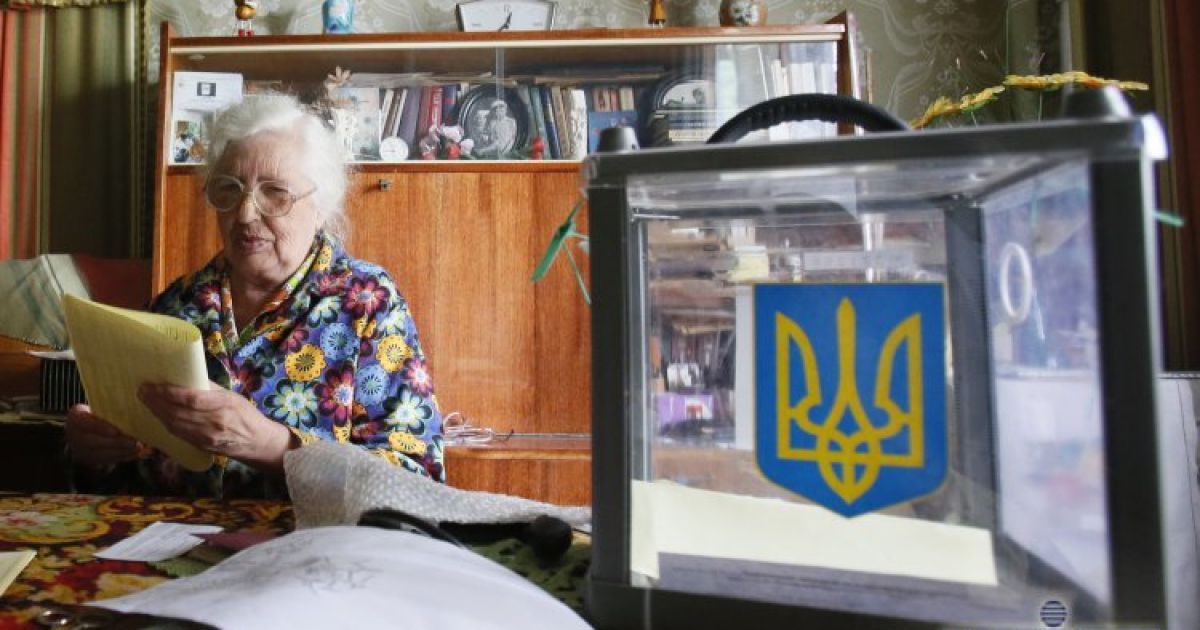 Літня жінка роздивляється бюлетень для голосування вдома у Василькові / © УНІАН