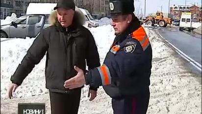 Самоскиди вивантажують сніг на проїжджу частину