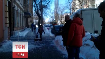 Чоловік збиває бурульки за допомогою  пневматичної гвинтівки