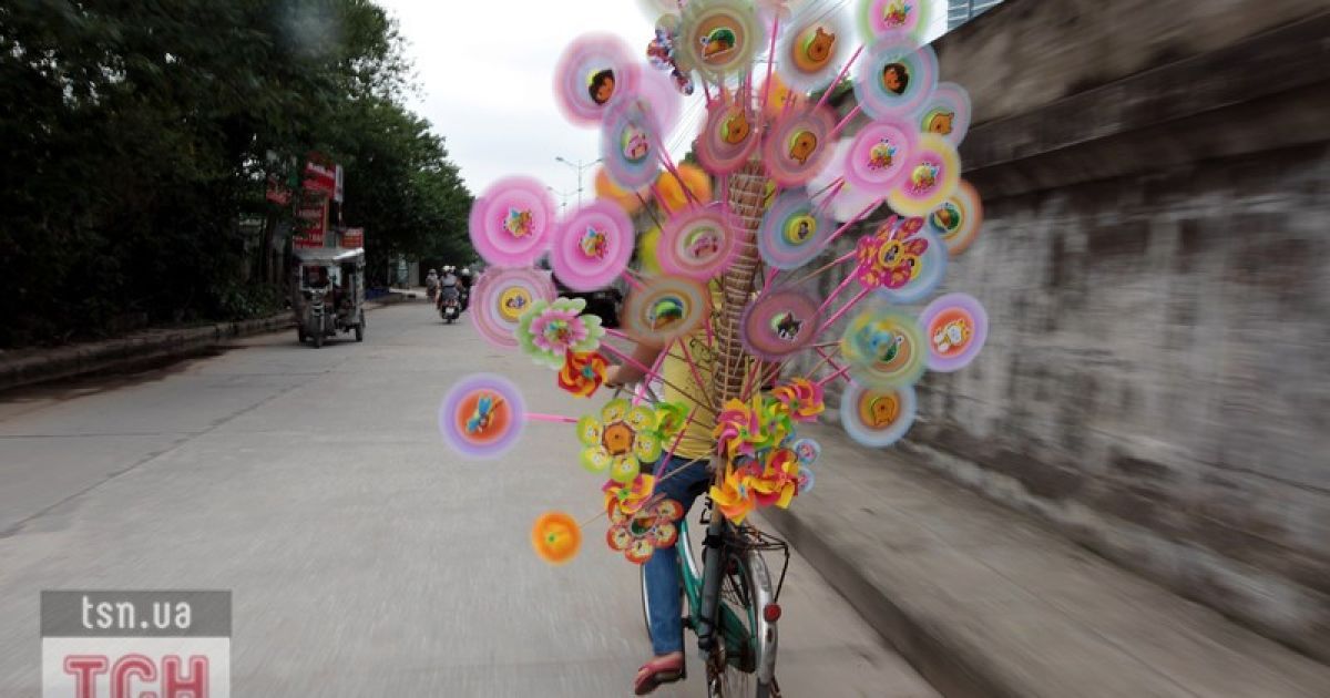 В'этнамська дівчинка на велосипеді продає свій товар / © Фото EPA/UPG