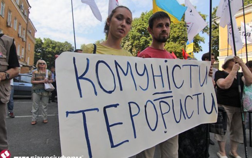 Активисты возле суда держат плакат с требованием запретить Компартию / © ЛігаБізнесІнформ