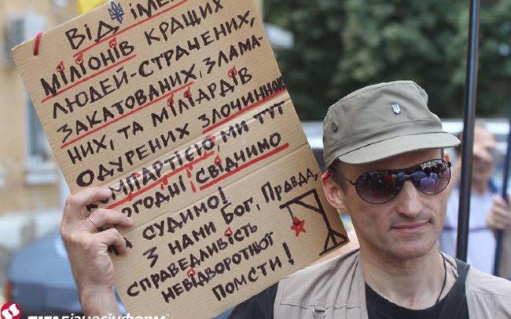 Активист держит плакат с требованием запрета Компартии / © ЛігаБізнесІнформ