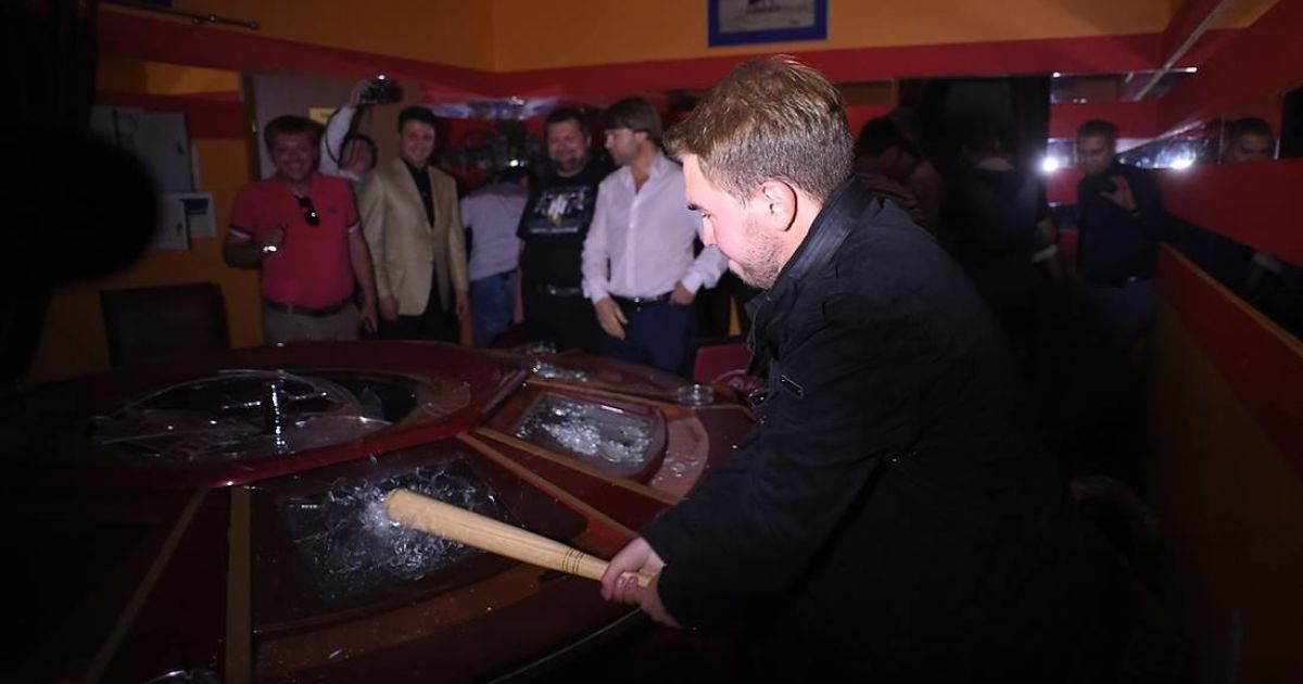 Мужчина из команды Ляшко разбивает игровой стол в незаконном казино на Троещине в Киеве / © facebook.com/O.Liashko