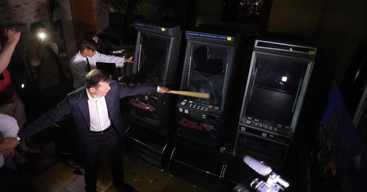 Олег Ляшко битой разбивает игровые автоматы на Троещине в Киеве / © facebook.com/O.Liashko