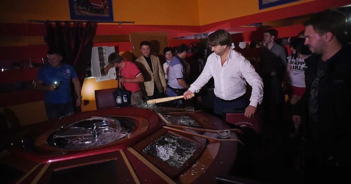 Мужчина из команды Ляшко разбивает игровой стол в незаконном казино на Троещине в Киеве / © facebook.com/O.Liashko