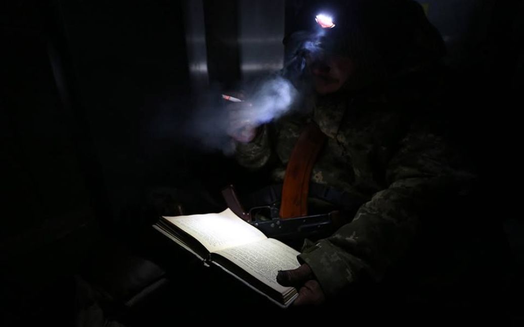 Украинский солдат читает книгу между боями / © facebook.com/sergei.loiko