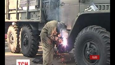 Вблизи Львова, на автобазе солдаты ремонтируют старые армейские машины и отправляют их на передовую