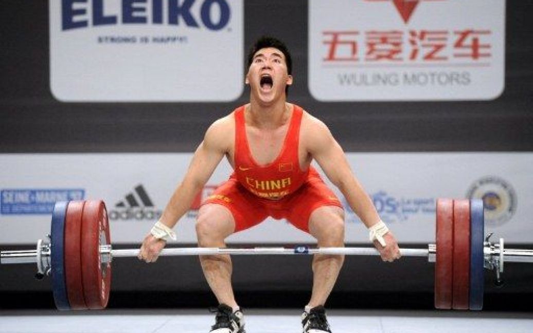 Франція, Париж. Китайський важкоатлет Су Даджин виступає у фіналі Чемпіонату світу з важкої атлетики 2011 у ваговій категорії 77 кг. / © AFP