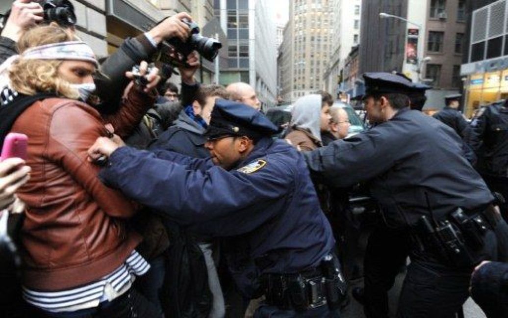 США, Нью-Йорк. Офіцери поліції відтісняють людей під час демонстрації на честь річниці протестів "Окупуй Уолл-стріт" в Нью-Йорку. Близько тисячі протестуючих зібралися на Уолл-стріт, де спалахнули сутички між поліцією і демонстрантами. / © AFP