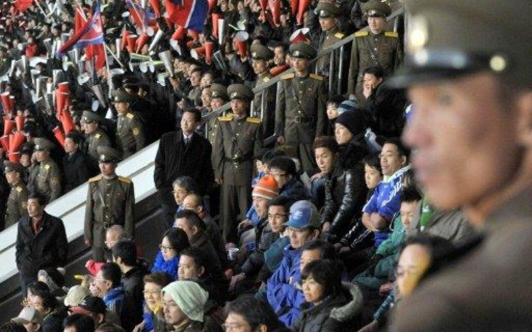 КНДР, Пхеньян. Співробітники північно-корейської служби безпеки стоять на сторожі навколо японських вболівальників під час відбірного матчу Чемпіонату світу 2014 у Пхеньяні. Японія зазнала поразки від Північній Кореї з рахунком 0:1. / © AFP
