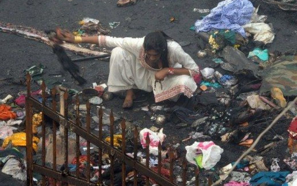 Індія, Нью-Делі. Євнух шукає речі серед сміття на місці великої пожежі у центрі євнухів. Щонайменше 15 євнухів загинули, 31 отримав поранення, коли вогонь охопив місце щорічного з&#039;їзду євнухів у Нью-Делі. / © AFP