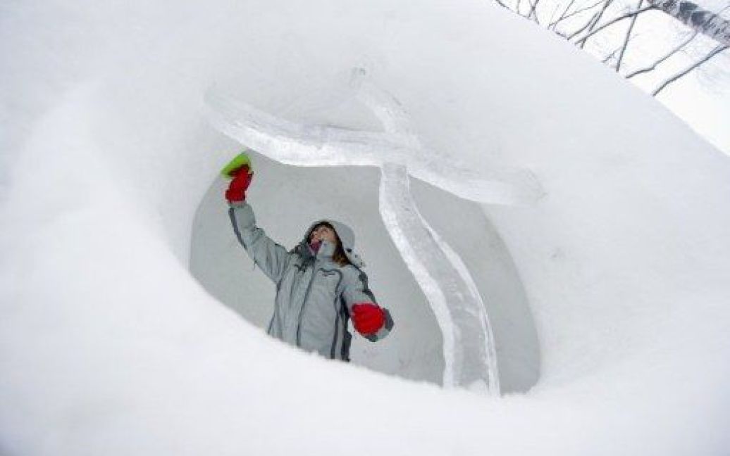 Росія, Москва. Жінка завершує снігову фігуру під час проведення зимового фестивалю снігових скульптур "Морозне Місто" у Москві. / © AFP