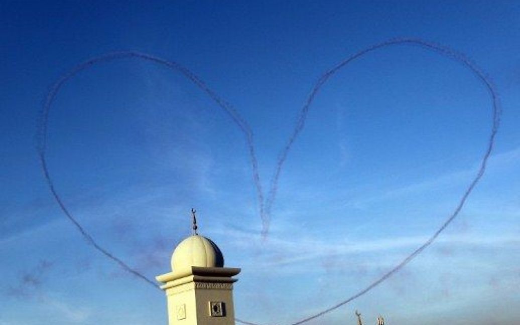Об&#039;єднані Арабські Емірати, Дубай. Аеробатична команда "Патруль де Франс" залишила слід у формі серця у повітрі над мінаретом мечеті під час виступу на авіасалоні в Дубаї. / © AFP