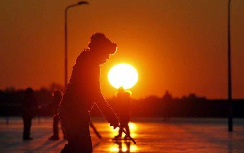 Нідерланди, Вітмарсум. Люди катаються на ковзанах на заході сонця. / © AFP