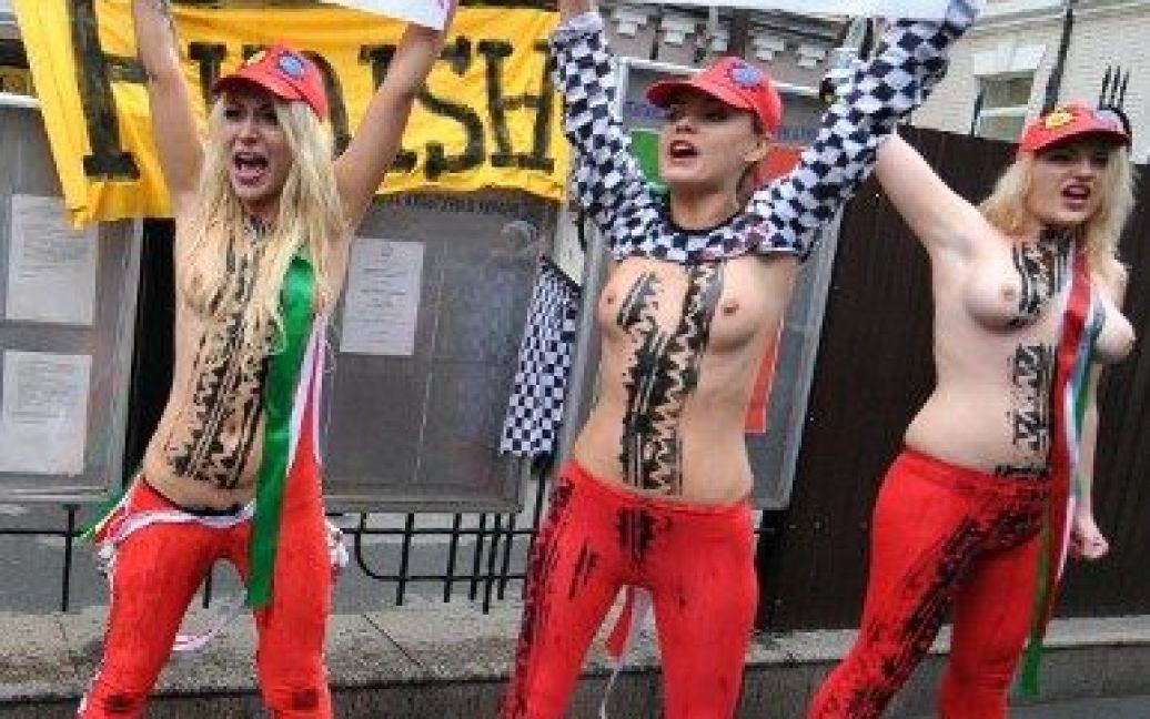 Україна, Київ. Активістки жіночого руху FEMEN влаштували святкову топлес-акцію перед посольством Італії в Україні. Дівчата пили шампанське на честь викрикували гасла і тримали плакати під час акції з нагоди відставки прем&#039;єр-міністра Італії Сільвіо Берлусконі. / © AFP