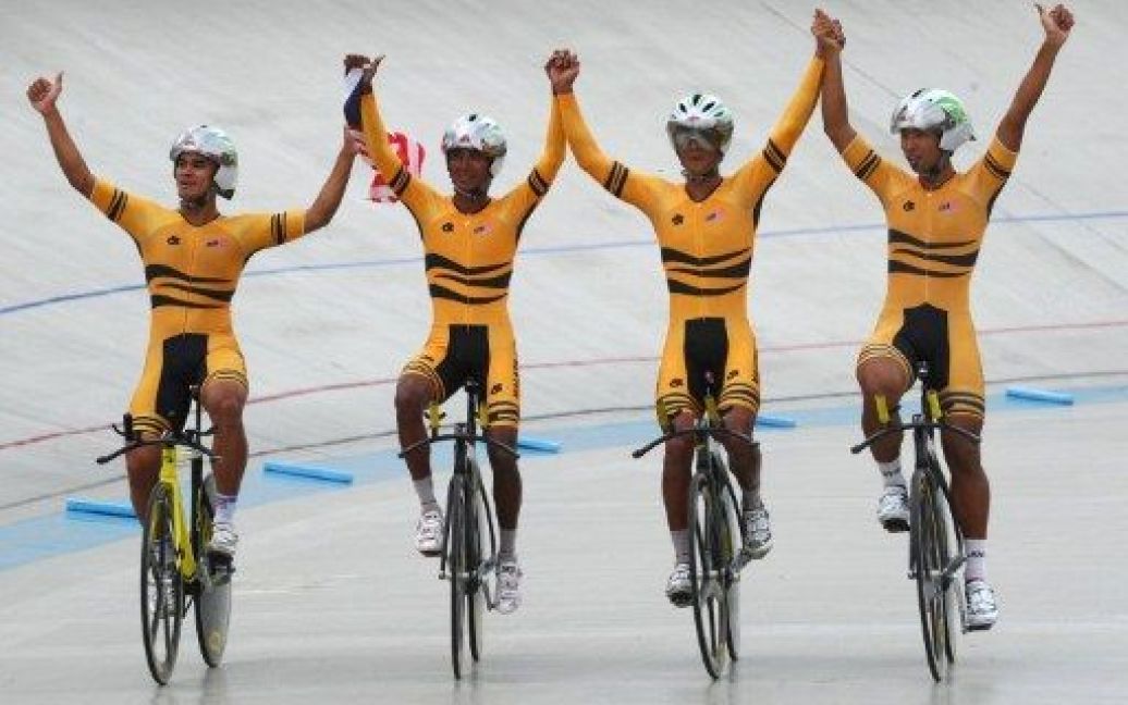 Індонезія, Джакарта. Команда малайзійських велосипедистів святкує перемогу у чоловічій командній гонці на 4000 м під час 26-их Південно-Азіатських Ігр (SEAGAMES). / © AFP