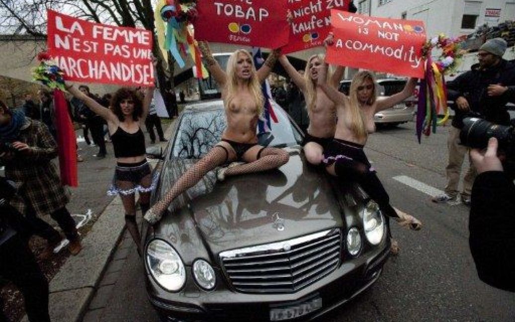 Швейцарія, Цюріх. Активісти жіночого руху FEMEN тримають плакати з написами "Жінка &mdash; не товар" під час топлес-протесту проти проституції та торгівлі жінками, який вони влаштували в районі сутенерів у Цюриху. / © AFP