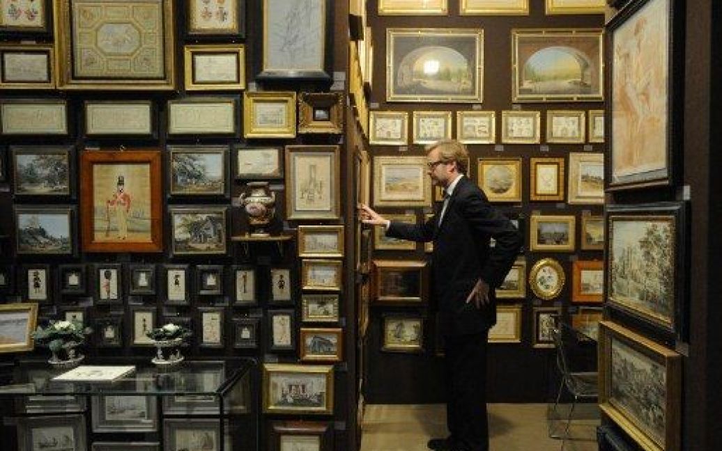 Великобританія, Лондон. Відвідувач роздивляється картини на 21-ому Зимовому салоні образотворчого мистецтва та антикваріату в Лондоні, який щороку приваблює десятки тисяч відвідувачів. / © AFP