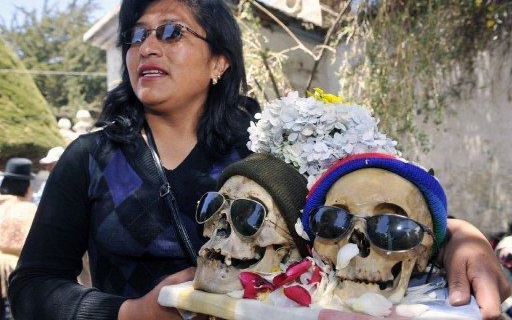 Болівія, Ла-Пас. Жінка несе "&ntilde;atitas" (людські черепи) на кладовище у місті Ла-Пас під час відзначення Дня черепів, або Дня смерті. / © AFP