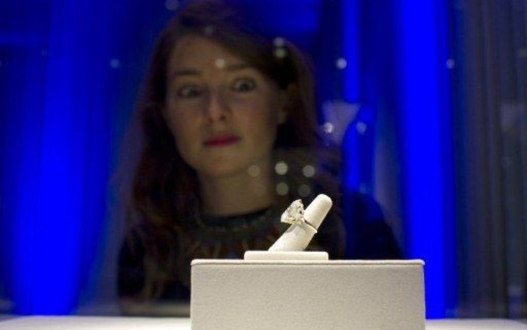 Франція, Париж. Жінка розглядає діамантове кільце Елізабет Тейлор, вартістю 2,5 мільйони доларів США, виставлене на продаж в аукціонному будинку Christie&#039;s. На аукціон також виставлені сотні дорогоцінних каменів, сукні та інші речі актриси, яка померла у березні 2011 року. / © AFP
