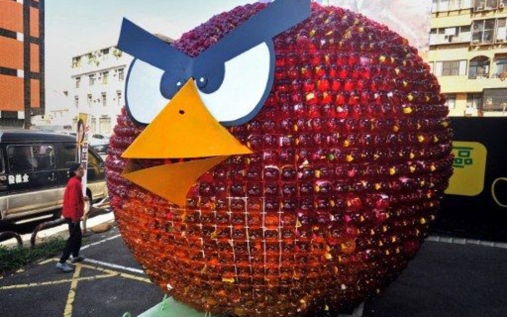 Тайвань, Тайчжун. Перехожий роздивляється фігуру персонажа відеогри Angry Birds, виготовлену зі скарбничок, яку встановили перед офісом опозиційної Демократичної прогресивної партії у Тайвані. Пташка є символом опозиціонерів. / © AFP