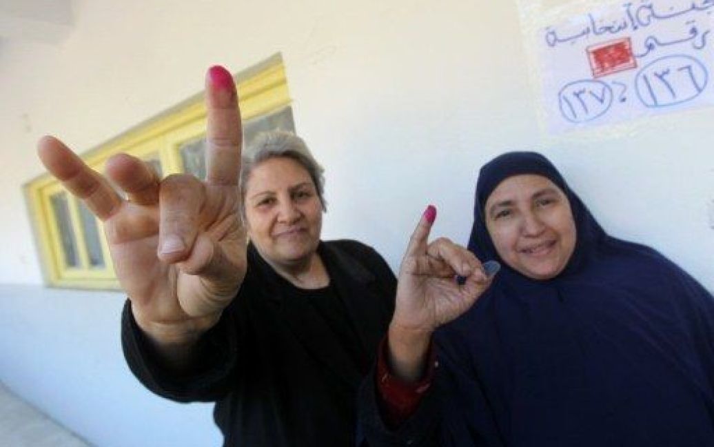 Єгипет, Каїр. Жінки показують свої пофарбовані чорнилом пальці після участі у голосуванні на виборчій дільниці в Каїрі, де провели повторні парламентські вибори. / © AFP
