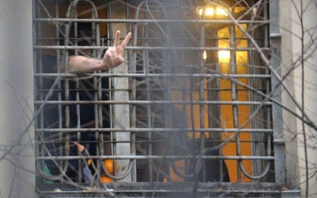 Росія, Москва. Активіст опозиції, затриманий під час акції протесту, показує знак перемоги з вікна своєї камери у слідчому ізоляторі Москви. / © AFP