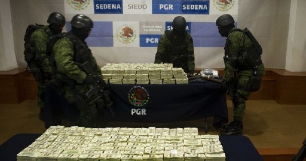 Мексика, Мехіко. Військові виносять стіл з понад 15 мільйонами доларів США після презентації в Мехіко. Гроші наркокартеля Гусмана Лоуера були вилучені під час спецоперації "Лиса" в Тіхуані. / © AFP