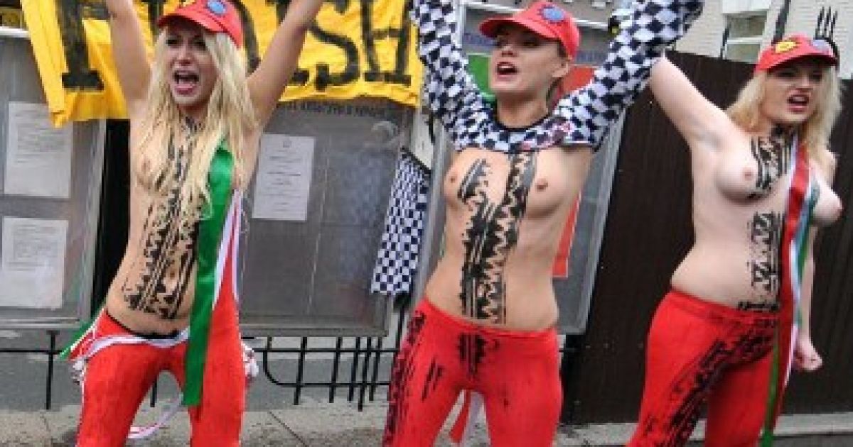 Україна, Київ. Активістки жіночого руху FEMEN влаштували святкову топлес-акцію перед посольством Італії в Україні. Дівчата пили шампанське на честь викрикували гасла і тримали плакати під час акції з нагоди відставки прем&#039;єр-міністра Італії Сільвіо Берлусконі. / © AFP