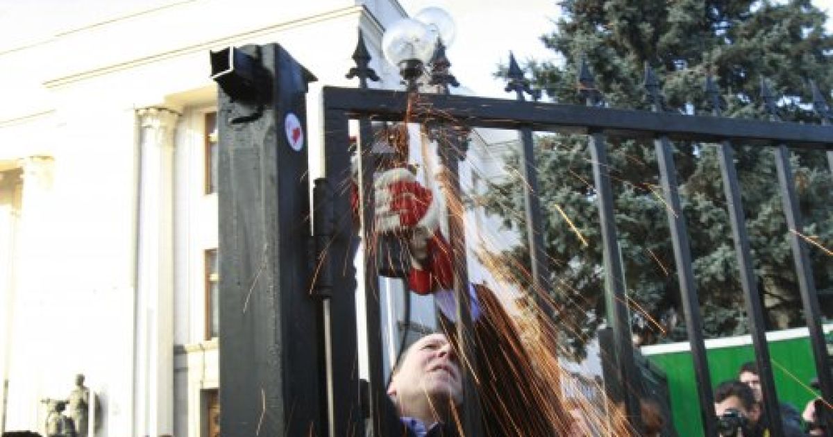 Опозиційні народні депутати зрізали болгаркою паркан, встановлений навколо будівлі Верховної ради.