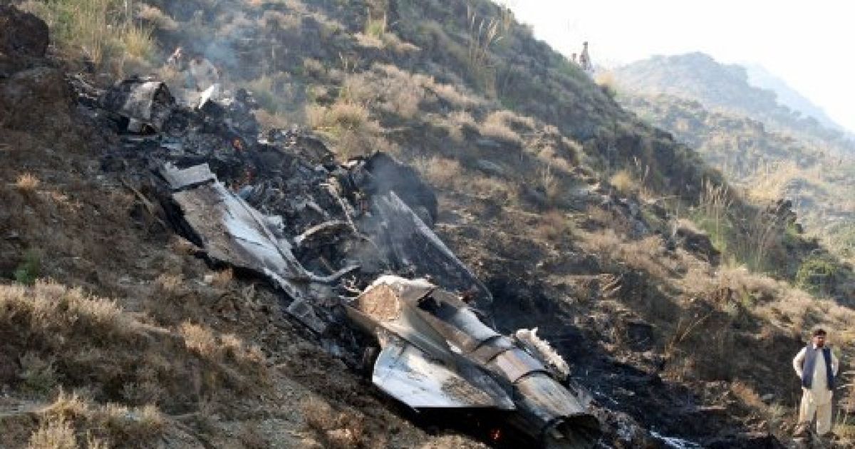 Пакистан, Аттока. Людина стоїть поруч з уламками пакистанського реактивного винищувача, який розбився поблизу міста Аттока. Літак ВПС Пакистану розбився під час тренувального польоту на півночі Пакистану, пілот загинув. / © AFP