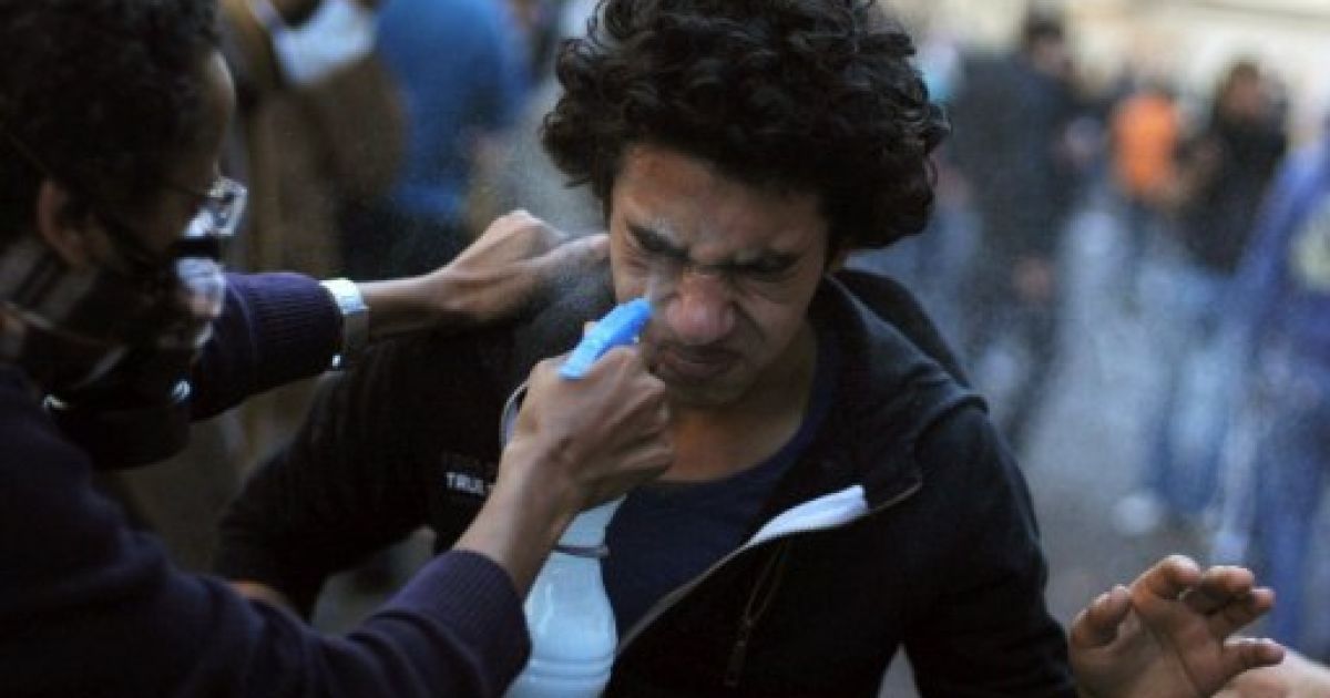 Єгипет, Каїр. Єгипетському демонстранту допомагають вмити обличчя після того, як у нього потрапив сльозогінний газ. Поліція та сили безпеки розганяють демонстрантів на площі Тахрір у Каїрі. Між поліцією та демонстрантами спалахують жорсткі сутички. / © AFP