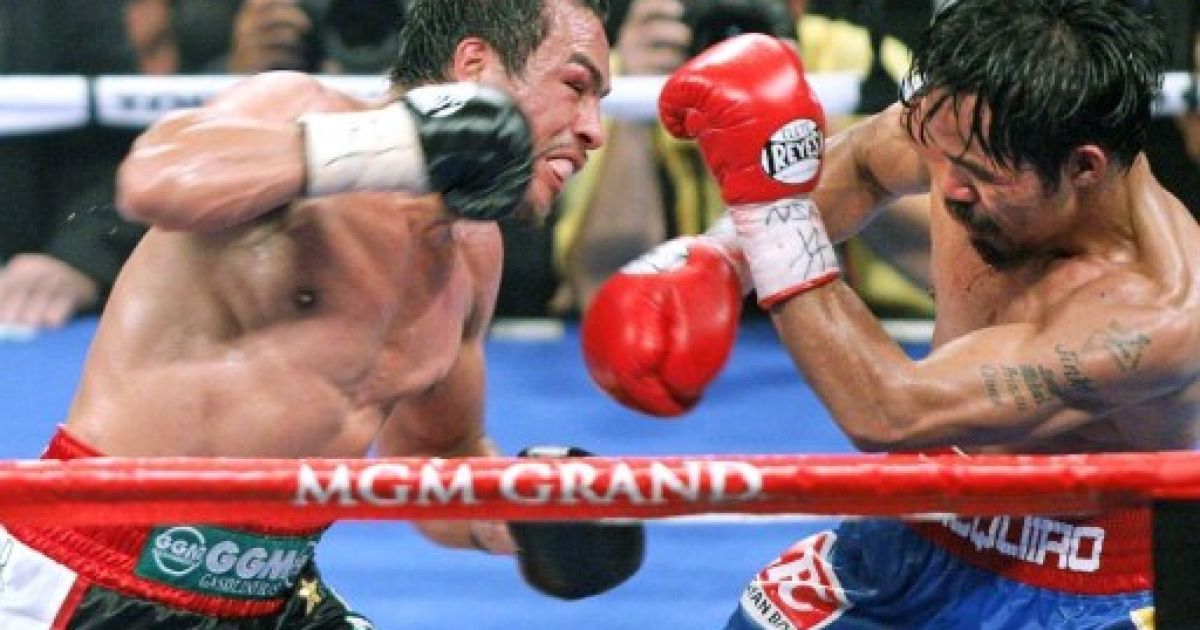 США, Лас-Вегас. Чемпіон світу за версією WBO у напівсередній вазі Менні Пакьяо захищається під час бою з Хуаном Мануелем Маркесом за чемпіонський пояс на арені MGM Grand Garden у Лас-Вегасі. Пакьяо захистив свій титул. / © AFP