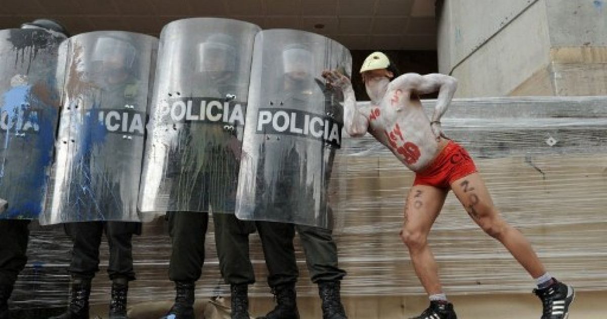 Колумбія, Богота. Студент жартує з поліцейськими під час демонстрації проти законопроекту про реформу освіти на головній площі Боготи Пласа-де-Болівар. Тисячі студентів з більш ніж 30 державних університетів вийшли на вулиці на знак протесту проти часткової приватизації вищої освіти. / © AFP