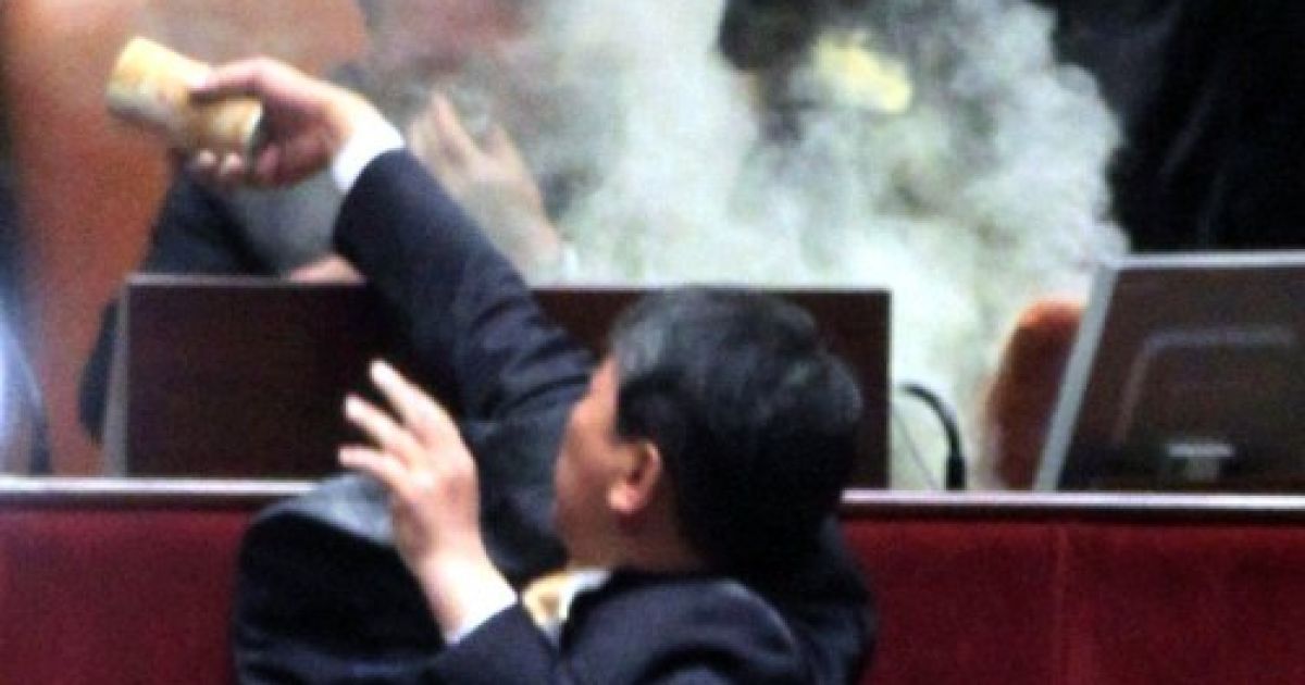 Республіка Корея, Сеул. Південнокорейський законодавець Кім Сун-Донг (Демократична партія праці) кидає бомбу зі сльозоточивим газом у спікера під час в Національних зборів у Сеулі під час розгляду законопроекту та угоди про вільну торгівлю зі США. / © AFP