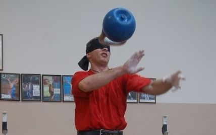 Чоловік із закритими очима жонглює 32-кілограмовою гирею