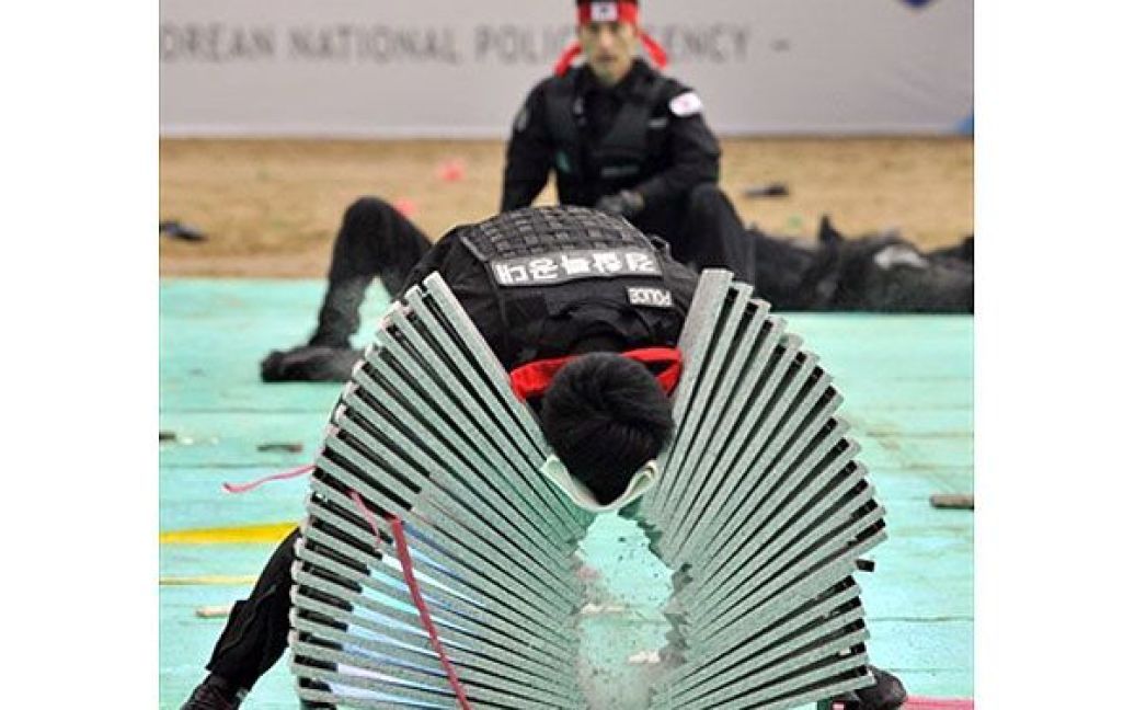 Республіка Корея, Сеул. Поліцейський з південнокорейського загону SWAT розбиває головою цеглу під час демонстрації своєї підготовки до саміту G20 на тренувальній базі у Сеулі. У південнокорейській поліції створили спецпідрозділ, який забезпечуватиме безпеку світових лідерів на саміті G20 у листопаді. / © AFP