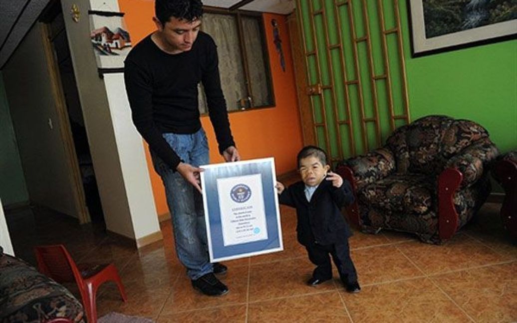 Колумбія, Богота. 24-річний колумбієць Едуард Ніньо Ернандес, зріст якого становить 70 сантиметрів, офіційно визнаний  найнижчою людиною у світі і занесений до Книги рекордів Гіннеса. Едуард Ніньо Ернандес разом зі своїм братом Юстином демонструє сертифікат про запис у Книзі рекордів Гіннеса. Едуарда визнали найнижчим у світі після того, як попередній власник титулу китаєць Він Пінгпінг, який був вищий на 4 сантиметри, помер 13 березня. / © AFP