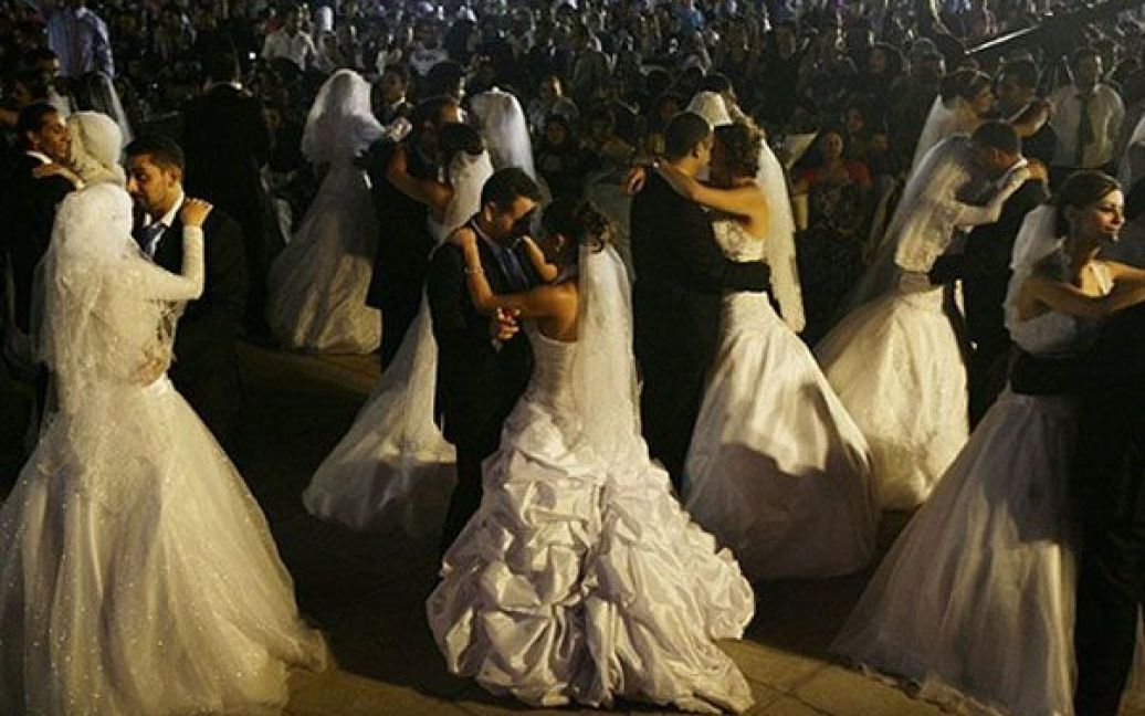 Ліван, Сидон. Наречені і женихи танцюють під час масового весілля, яке організував лівано-палестинський комітет у справах розвитку на чолі з ліванським депутатом Бахійя Харірі у південному портовому місті Сидон. Під час церемонії у шлюб вступили 77 ліванських і палестинських мусульманських і християнських пар. / © AFP