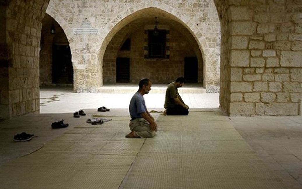 Чоловіки моляться у мечеті у Старому Місті у Тріполі. Зараз в мусульман триває священний місяць Рамадан. / © AFP