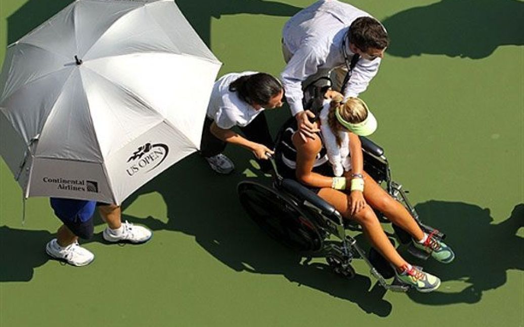 Вікторію Азаренко, яка знепритомніла під час матчу проти аргентинки Гізели Дулко, довелося забирати з корту на інвалідному візку. / © AFP