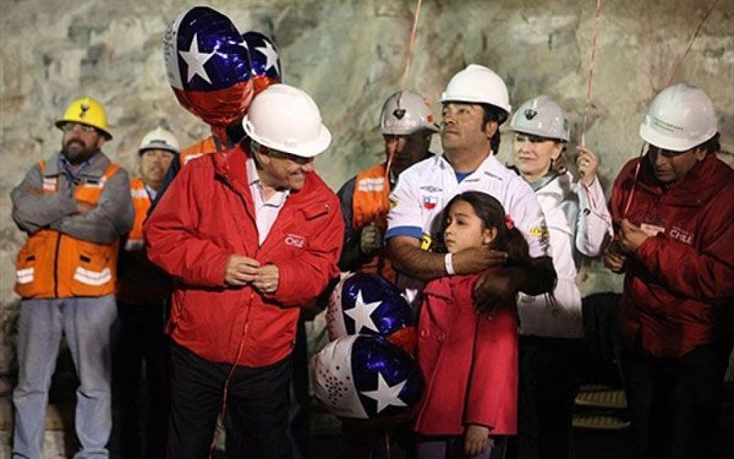 Президент Чилі Себатьян Піньєра дивиться на дівчинку, яка чекає на порятунок шахтарів / © AFP