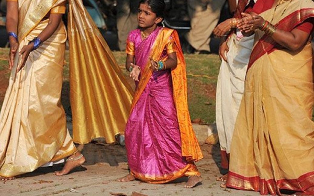 Індія, Хайдарабад. Індійська дівчинка танцює разом із членами партії "Бхаратія Джаната" на святкуванні Батхукамми, або фестивалю "Того, хто дає життя", у Хайдарабаді. Жінки вітають Батхукамму, який "дає життя", квітами, які означають життя і вічність, моляться про процвітання і хороший рік. / © AFP