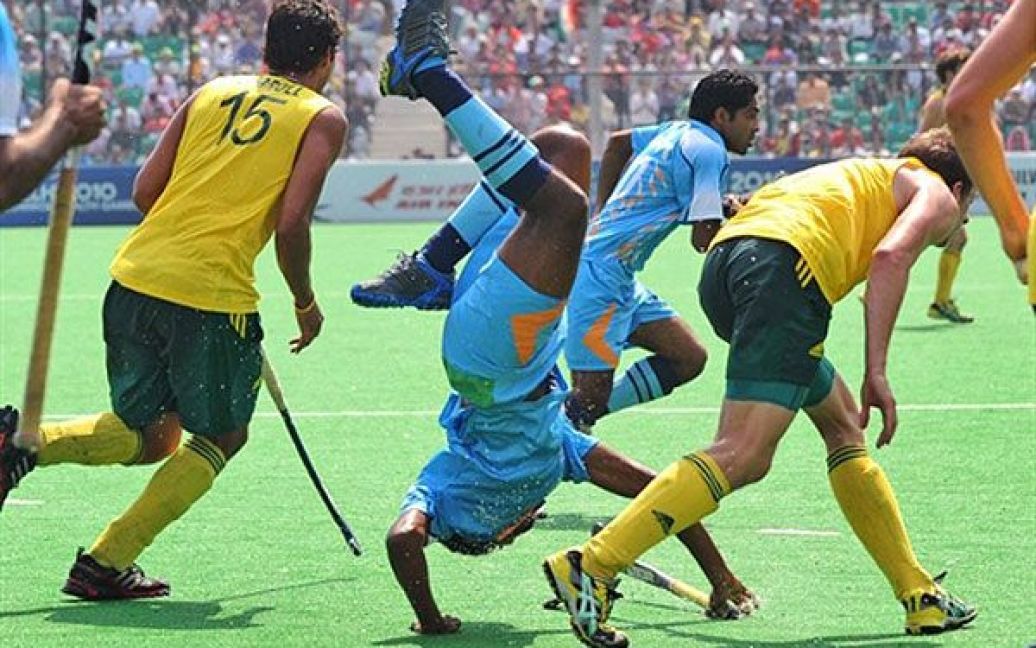 Індія, Нью-Делі. Індійський гравець Прабодх Тіркі падає після зіткнення з австралійським захисником у фіналі з хокею на траві серед чоловіків на Іграх Співдружності у Нью-Делі. Австралія виграла у Індії з рахунком 8-0. / © AFP
