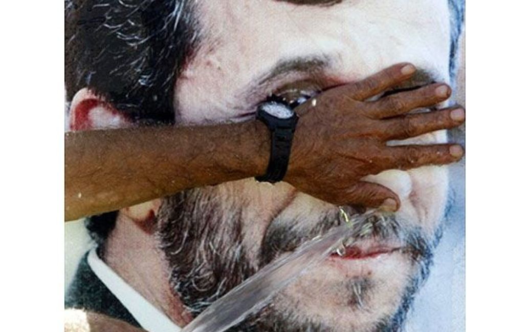 Ліван, Марун аль-Рас. Чоловік зі шлангу поливає зображення президента Ірану Махмуда Ахмадінежада у "Іранських садах" у південному ліванському місті Марун аль-Рас. Ліван готується до офіційного візиту президента Ірану, який має відбутися 13-14 жовтня. / © AFP